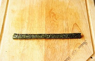 小花寿司,用手将卷好的小寿司卷掐紧,掐圆,形成一个花瓣;
