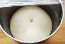 面包超人挤挤面包,盖保鲜膜室温发酵至原来的2倍大,手指沾面粉戳洞,洞口不收缩不塌陷为最佳;
