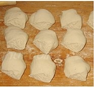 熏肉笋丁馅儿饼,取出发酵好的面团,放在面板上揉匀揉透,下剂子,搓圆,擀皮儿,包馅儿;