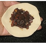 熏肉笋丁馅儿饼,完成后的馅儿饼生坯,放在面板上,盖保鲜膜松弛一刻钟左右;
