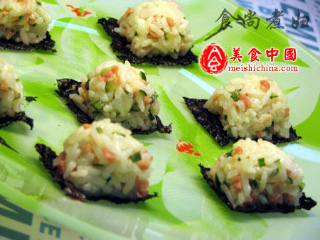 简易饭团,将切好的饭团摆在海苔片上，海苔片和饭团一起吃