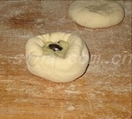 土豆泥黑豆馅饼,取一个小圆饼,轻轻按扁,放入适量的馅儿芯料,用虎口将其团入面皮内,捏紧收口;