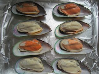 泡椒芝士焗青口贝,青口解冻、洗净,挤入适量的柠檬汁。摆入烤盘内。