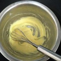 奶酪饼干,将奶油奶酪掰成小块,加细砂糖,蛋黄,隔热水搅拌至顺滑无颗粒;加入黄油,继续搅拌至黄油融化,面糊顺滑。