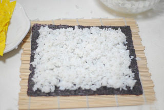 爽食寿司卷,在寿司帘上放上<a style='color:red;display:inline-block;' href='/shicai/ 75430'>寿司紫菜</a>,将米饭铺平,不要压饭粒,尽量保持饭粒完整,松软,四周稍微留一点边。