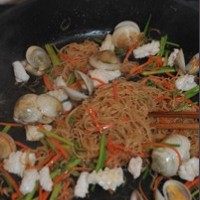 海鲜炒米粉,放一些鸡精调味,倒入前面炒好的鱿鱼卷,翻炒均匀即可出锅。