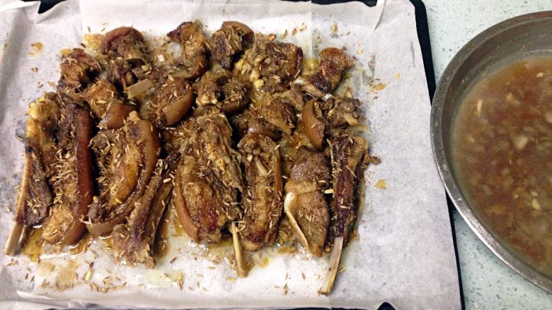 孜然烤羊排,取出羊排,揭去锡纸,淋一点蒸盘里的汤汁,两面均匀洒上剩下的混合香料,不盖锡纸,再入烤箱200度烤8分钟。