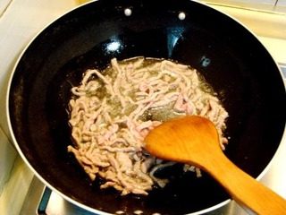 什锦炒面,炒锅上火烧热,注入适量花生油滑散肉丝