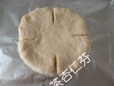 奶酪花环面包,用剪刀现在圆饼的边缘均等地剪出四个刀口,再在每两个刀口间均等地剪个两刀口。