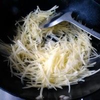醋溜土豆丝,放入土豆丝大火翻炒,并放入适量盐