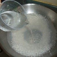 杨枝甘露,当锅中的西米煮沸后,加入清水,再次盖上盖子煮。