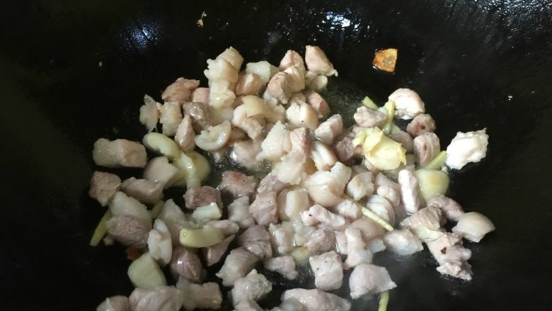 卤肉饭,将锅中底油中火加热,放2-3瓣拍烂的蒜和几根姜丝爆香,再放入肉丁