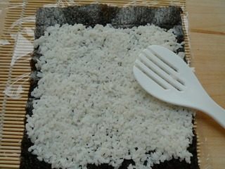 花朵寿司,将米饭平铺在紫菜上,薄薄的一层。