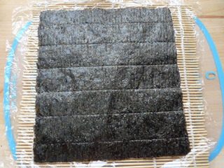 里卷寿司,取一个寿司帘,放保鲜膜,放一张<a style='color:red;display:inline-block;' href='/shicai/ 279'>海苔</a>。