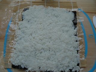 里卷寿司,米饭从左自右，从上至下铺好，盖住海苔。