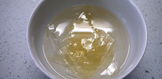 巧克力牛奶双色布丁,吉利丁片用凉水浸泡到变软，捞出沥干，放小碗中，隔热水搅拌至溶化成液态。