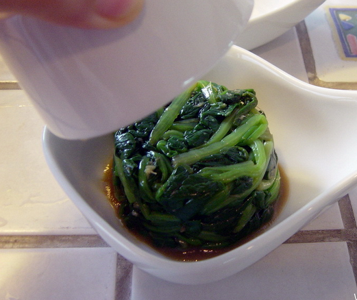 姜汁菠菜,放入姜泥和调料将菠菜拌匀,用一个直筒的矮杯子将拌好的菠菜装进去,压紧,然后迅速倒扣过来,表面用姜茸和辣椒以及适量芝麻装饰即可。
