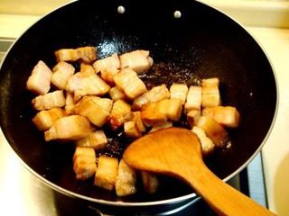 梅干菜烧肉,把冰糖煸成琥珀色后,下入煮过并沥干水份的五花肉进行煸炒。