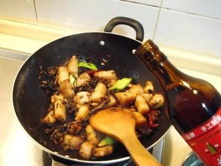 梅干菜烧肉,葱姜辣椒煸出香味后下入梅干菜煸炒。把梅干菜炒至干香后，烹入黄酒炒匀。