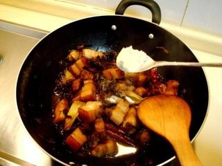 梅干菜烧肉,把肉焖40分钟后,用大火收汁,然后撒少许盐调味。放大约2克鸡粉提鲜炒匀。