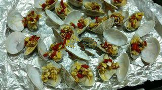 蒜香烤花蛤,用筷子把配料夹在花蛤肉上;