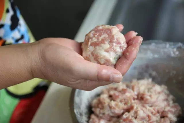最好吃的扬州狮子头 ,电饭煲放入开水，根据自己的喜好，放入盐，<a style='color:red;display:inline-block;' href='/shicai/ 788'>生抽</a>，<a style='color:red;display:inline-block;' href='/shicai/ 762'>老抽</a>，按下保温按钮（此时水不能沸腾，火力大了，狮子头下锅就会冲散，不成型）。取出部分搅拌好的肉馅，左右手像抛球一下搬弄肉馅（不要很高，就左右手快递互换），慢慢肉馅就变成圆圆的肉圆啦，小心放入水中。同样方法重复。动作要快，手势要轻柔。这样狮子头的形状才会好看。