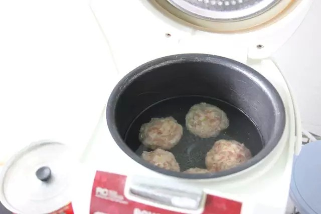 最好吃的扬州狮子头 ,等全部肉馅都做成狮子头放入电饭煲中，按下煮饭按钮，火力加大，等到水沸腾后，再转为“保温”，这点很重要很重要，用短时间的大火将狮子头的表层凝结，整个狮子头就不容易散，再减小火力慢炖，锁住肉味。