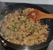 香菇肉丁油饭,转大火不停翻炒至米饭和所有材料均匀,并且饭粒干爽,撒葱花拌匀即可出锅