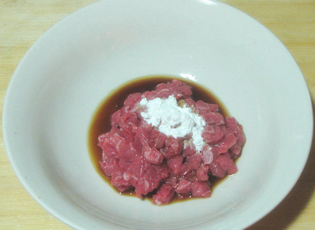 彩椒牛肉粒,牛肉用厨房用纸蘸去血水之后切成小丁。取一个小碗,放入1小勺<a style='color:red;display:inline-block;' href='/shicai/ 718'>料酒</a>、1小勺酱油和1小勺淀粉拌匀,腌制10分钟。然后倒入一点点油用手抓匀,再静止30分钟。