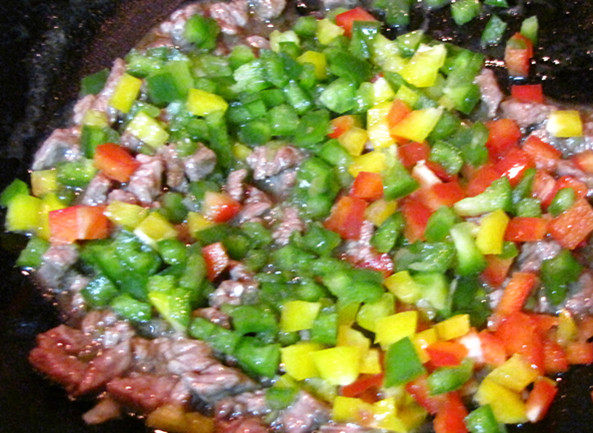 彩椒牛肉粒,锅热后倒入食用油,先放入葱末炒出香味后放入牛肉丁。