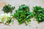 香草海盐烤鸡翅,将香草切成细丝,百里香从茎部摘下来。蒜切成末