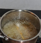 酥炸小黄鱼,开大火把锅中的油烧到很热,放入第一遍炸好的小黄鱼,复炸20秒左右至鱼表面呈金黄色