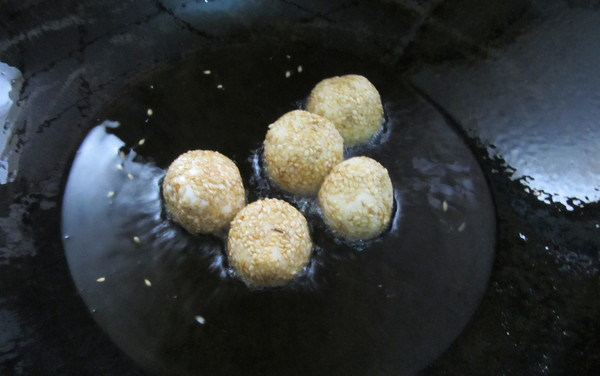 四川糖油果子,油烧热,将糯米团放入锅中炸制