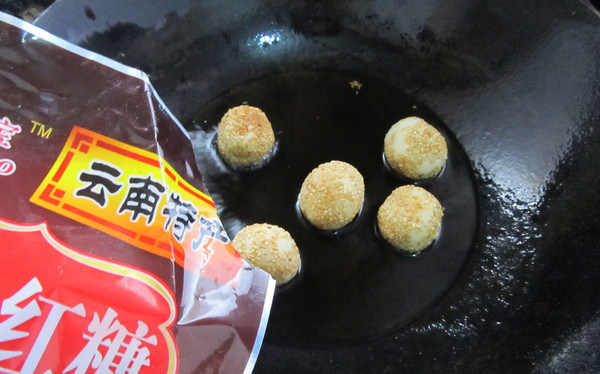 四川糖油果子,糯米团表面变金黄后放入红糖,将红糖化开,糯米团粘上红糖即可出锅