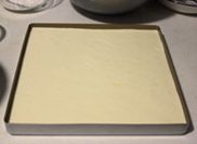 柠檬果冻蛋糕,取1/3蛋白混合蛋黄糊后加入全部蛋白翻拌混合均匀,倒入不粘方形烤盘,刮平后震出大气泡