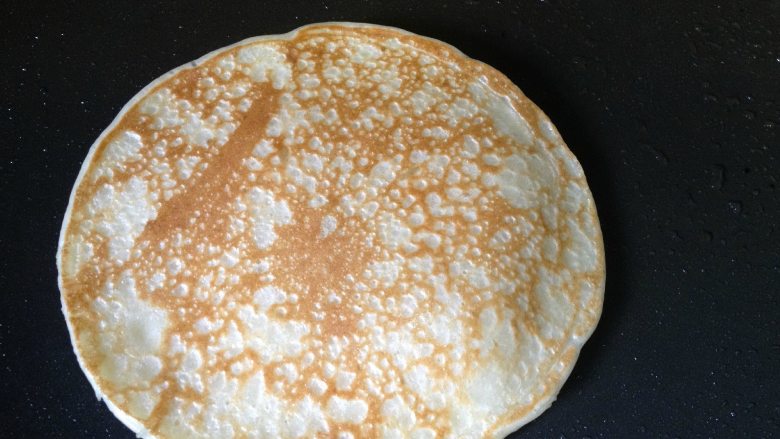 香蕉糯米饼,等面糊产生许多气孔,边缘完全凝固(是边边不是全部),用平铲翻面