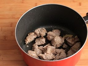 排骨蛤蜊,锅中下油和姜片,倒入排骨翻炒至表皮收紧;