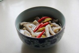 泡椒凤爪,在沥干水的凤爪中倒入酿造的白醋,盐,泡椒,一点白糖,凉开水,盖上盖子,浸泡一天即可