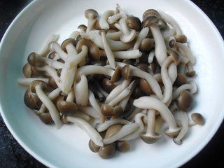 海鲜豆腐煲,菇去根洗净焯水;