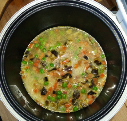 电饭锅什锦焖饭,倒入适量的清水,水量刚好没过饭菜即可。