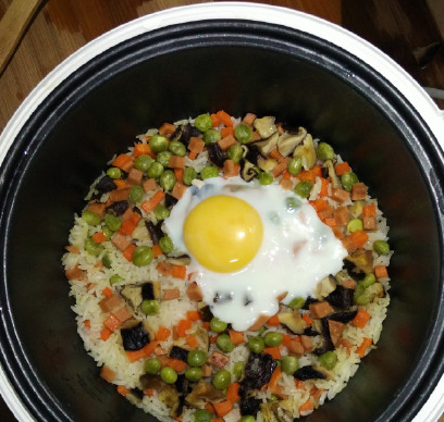 电饭锅什锦焖饭,出锅前,取出鸡蛋(鸡蛋可以撒点盐和胡椒粉),把饭和蔬菜拌匀。