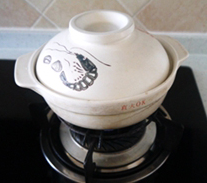 腊味煲仔饭 ,擦干净瓦煲外的水，开小火慢慢加温后，转中小火焖上米饭。