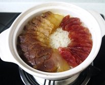 腊味煲仔饭 ,15-20分钟，看米饭水分蒸干，基本成熟后，均匀铺上腊肉和腊肠，沿着瓦煲边缘放下剩下的1/2匙油，放米饭底部开始结起锅巴，这个过程火力要调更小一点。