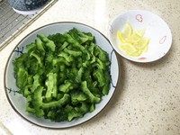 日式腌柠檬苦瓜片,用力将苦瓜片挤出水,这时可以尝一下味道,如果苦瓜咸味够了,等下的腌制调味汁就可以少加盐或不加盐。如果太咸可以用纯净水快速冲一下,然后挤干水。切4片<a style='color:red;display:inline-block;' href='/shicai/ 595'>柠檬</a>,<a style='color:red;display:inline-block;' href='/shicai/ 595'>柠檬</a>比较大的话3片就可以了,每片<a style='color:red;display:inline-block;' href='/shicai/ 595'>柠檬</a>十字切成4片。