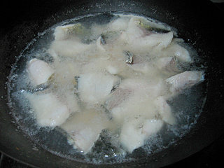 椒麻水煮鱼片,鱼肉汆水:锅中入水开火,水开后下入鱼肉划散,待鱼肉发白捞出。(鱼片不要煮久,否则就不嫩了。比较薄的鱼片1、2分钟足够,实在把握不住可以过一两分钟尝一下最厚的鱼片来判断。)