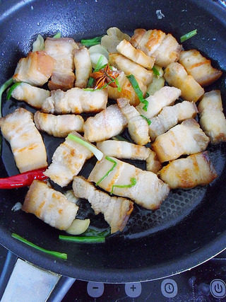 毛氏红烧肉,炒香后把煎好的五花肉放入锅内翻炒下后,加入料酒10g,炒匀。