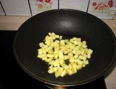 土豆培根焗饭,锅中倒油(比平时炒菜多一些),先把土豆丁中小火煸至边缘略焦;