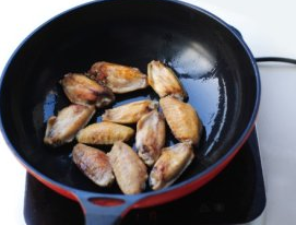 可乐鸡翅,锅里倒油烧热,放入鸡翅,煎到两面泛黄。