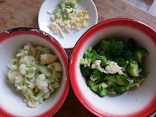 五花肉炒双花,将花菜和西兰花,用开水焯一下,花菜焯水时间比西兰花时间长,焯水时在锅里加点食用油。葱切葱花,姜切碎,蒜切碎。