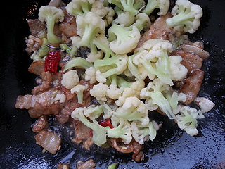 五花肉炒双花,加入花菜,翻炒均匀。